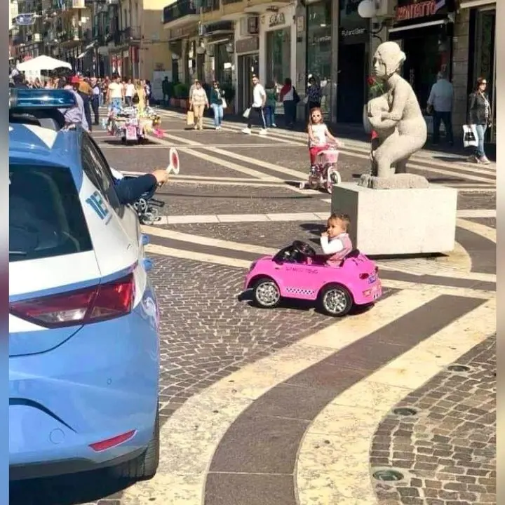 La polizia ferma una bimba alla guida della sua “auto” sull’isola pedonale a Cosenza, la foto diventa virale sui social