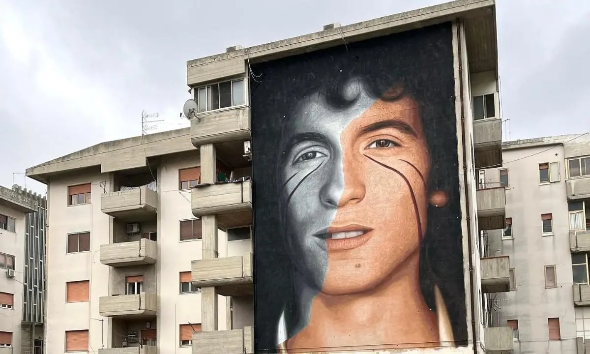 Jorit “imbratta” Crotone con il volto di Rino Gaetano: ecco chi è il Banksy italiano