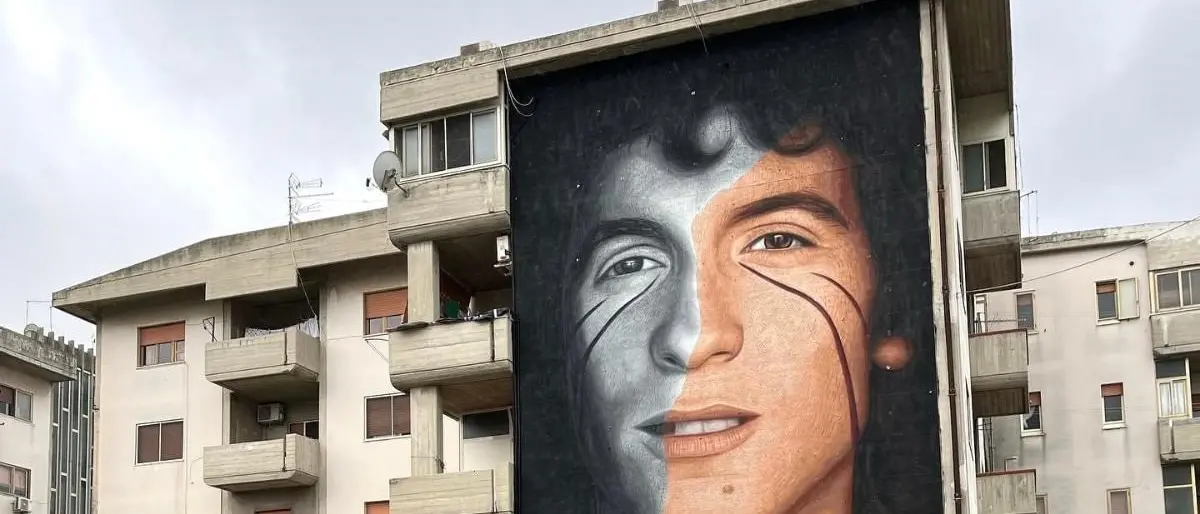 Jorit “imbratta” Crotone con il volto di Rino Gaetano: ecco chi è il Banksy italiano