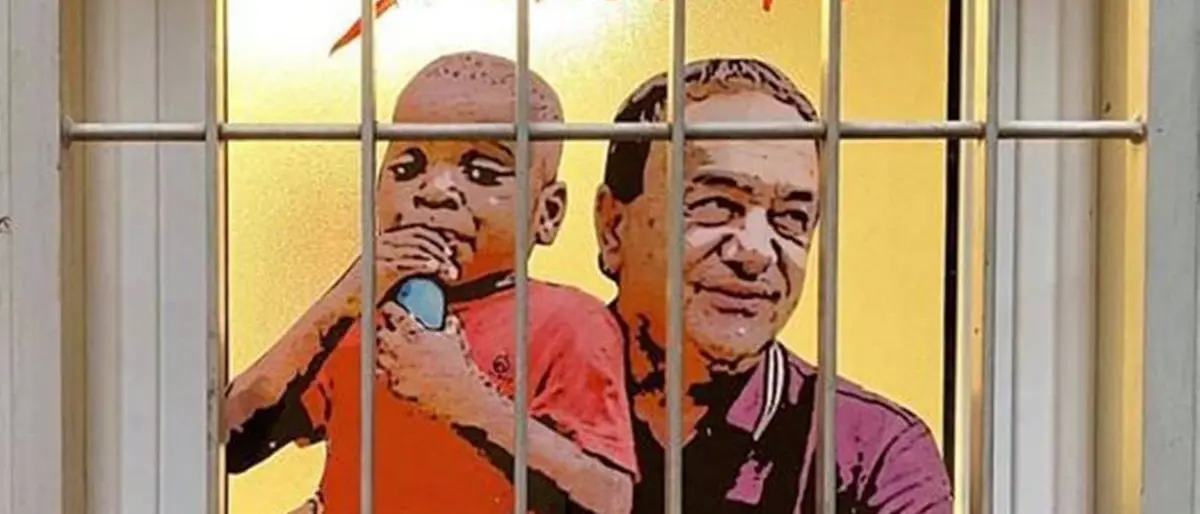 Lucano dietro le sbarre con un piccolo migrante in braccio: la nuova opera di TvBoy