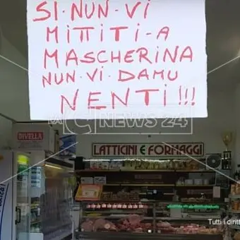 «Senza mascherina non vi diamo niente»: l'avviso all'ingresso di un negozio di Praia a Mare