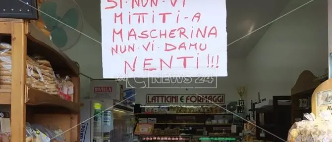 «Senza mascherina non vi diamo niente»: l'avviso all'ingresso di un negozio di Praia a Mare