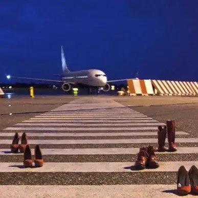 Scarpette rosse sulla pista dell’aeroporto contro la violenza sulle donne