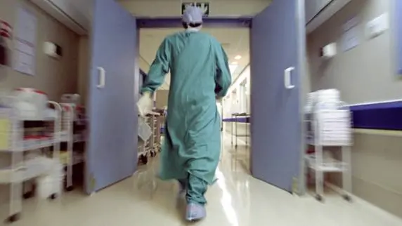 Doctor rushing in hallway , Getty Images/Pixland