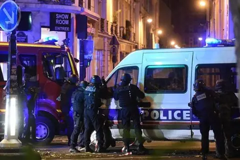 epa05024070 Police officers gather outside the Bataclan concert venue in Paris, France, 13 November 2015. At least 149 people have been killed in a series of attacks in Paris on 13 November, according to French officials. EPA/CHRISTOPHE PETIT TESSON , EPA