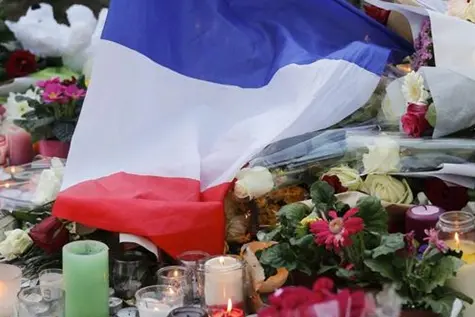 epa05026829 A french flag and flowers are placed at a memorial set near the Bataclan concert venue in Paris, France, 15 November 2015. More than 120 people have been killed in a series of attacks in Paris on 13 November, according to French officials. Eight assailants were killed, seven when they detonated their explosive belts, and one when he was shot by officers, police said. French President Francois Hollande says that the attacks in Paris were an \\'act of war\\' carried out by the Islamic State extremist group. EPA/JULIEN WARNAND , EPA