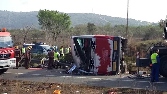 Emergency services personnel stand at the scene of a bus accident crashed on the AP7 highway that links Spain with France along the Mediterranean coast near Freginals halfway between Valencia and Barcelona early Sunday, March 20, 2016. The bus was reportedly hired out to carry students to and from a fireworks festival in Valencia and was on the return leg of its journey when the accident happened. (AP Photo) , AP