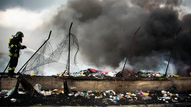 Caivano (provincia di Napoli- febbraio 2012- Un vigile del fuoco impegnato a spegnere un rogo appiccato a rifiuti speciali e urbani. Nella cosiddetta Terra dei Fuochi basta spulciare i documenti dei Vigili del Fuoco ,dove sono registrati i tantissimi interventi dei pompieri per i roghi tossici, per capire la portata del fenomeno relativo ai roghi tossici. Da molti anni, la camorra e le piccole imprese che producono in nero e sono costrette a smaltire i rifiuti in nero, usa il sistema dei roghi tossici per liberarsi dei rifiuti e degli scarti industriali di ogni tipo.