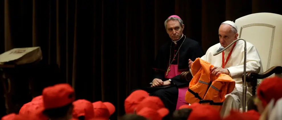Papa Francesco con un salvagente in mano per spiegare chi sono i migranti