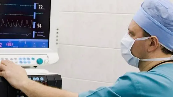 anesthesiologist with equipment in operation room