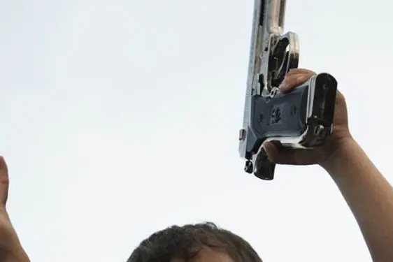 A Libyan child holds a pistol as he sits on his father\\'s shoulders at the site of a blast in the parking lot of the Tibesti hotel, used by rebel leaders, diplomats and journalists, in the eastern rebel stronghold of Benghazi on June 1, 2011. AFP PHOTO/GIANLUIGI GUERCIA (Photo credit should read GIANLUIGI GUERCIA/AFP/Getty Images) , AFP/Getty Images