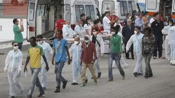 Un momento dello sbarco dalla nave della Marina militare \"Euro\", giunta nel porto di Crotone con a bordo 956 migranti, di varie nazionalit\\u00E0, soccorsi nei giorni scorsi a sud di Lampedusa mentre si trovavano a bordo di due barconi. Del gruppo fanno parte 122 bambini, alcuni piccoli, 224 donne, alcune delle quali incinte, e 610 uomini, Crotone, 13 Settembre 2014. ANSA/GIUSEPPE LAMI , ANSA