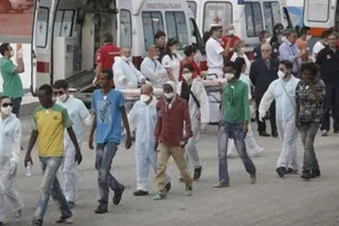 Un momento dello sbarco dalla nave della Marina militare \"Euro\", giunta nel porto di Crotone con a bordo 956 migranti, di varie nazionalit\\u00E0, soccorsi nei giorni scorsi a sud di Lampedusa mentre si trovavano a bordo di due barconi. Del gruppo fanno parte 122 bambini, alcuni piccoli, 224 donne, alcune delle quali incinte, e 610 uomini, Crotone, 13 Settembre 2014. ANSA/GIUSEPPE LAMI , ANSA