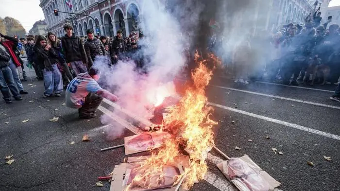A Torino, al termine di un corteo di studenti, centri sociali e pro Palestina, alcune centinaia di manifestanto hanno bruciato una sagoma di stracci raffigurante il volto del ministro delle Infrastrutture Matteo Salvini e tre maxi foto coi i volti della premier Giorgia Meloni, del ministro della Difesa Guido Crosetto e del ceo di Leonardo, Roberto Cingolani. 29 novembre 2024 ANSA/TINO ROMANO , ANSA