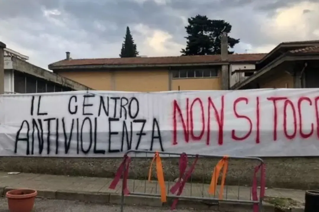 Lo striscione di protesta fuori la sede del centro antiviolenza Lanzino