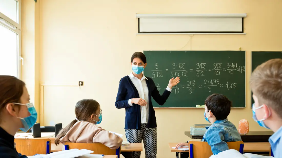 A teacher wearing a N95 Face masks teaches mathematics at an High School , Getty Images