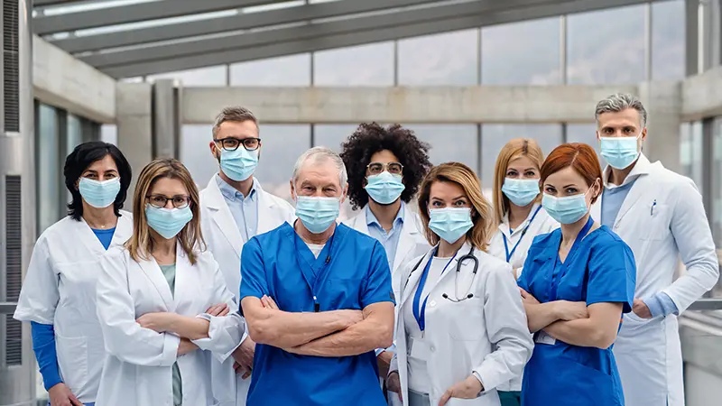 A group of doctors with face masks looking at camera, corona virus concept. , Getty Images/iStockphoto