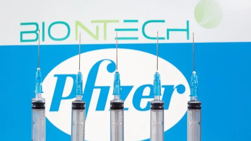 Cinque siringhe davanti ai logo Pfizer e BioNTech . REUTERS/Dado Ruvic , REUTERS