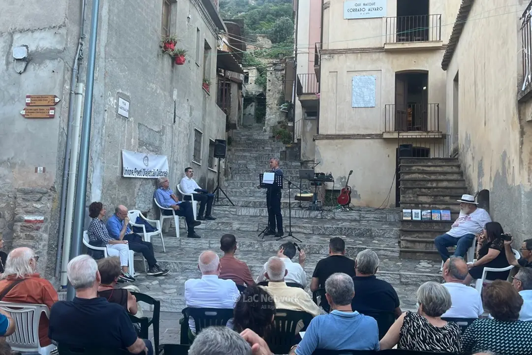 <p>Il reading dei Poeti per la Pace nello slargo davanti alla casa natia di Corrado Alvaro a San Luca</p>\\n