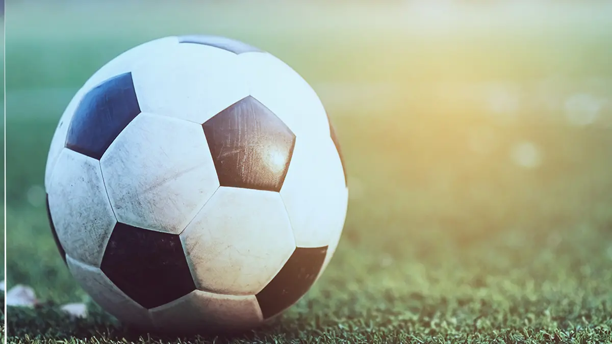 Old football in the green artificial grass field - football or soccer sport game competition concept