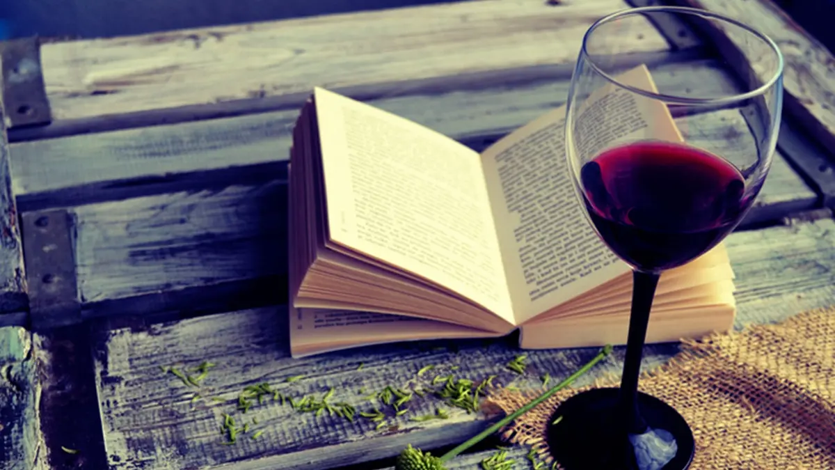 Open book with wine glass on a wooden background , Getty Images/iStockphoto