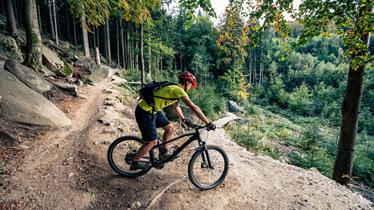 Cycling in autumn inspirational mountains landscape. Mountain biker riding on bike on forest dirt trail. Man cycling MTB on enduro track. Sport fitness motivation and inspiration. , Getty Images/iStockphoto
