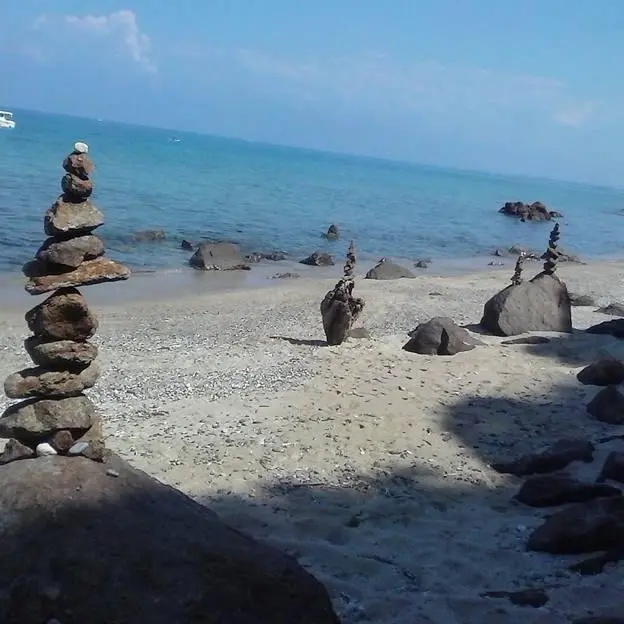 Il “naufrago” di Timpa Janca che realizza totem di sassi e pulisce la spiaggia