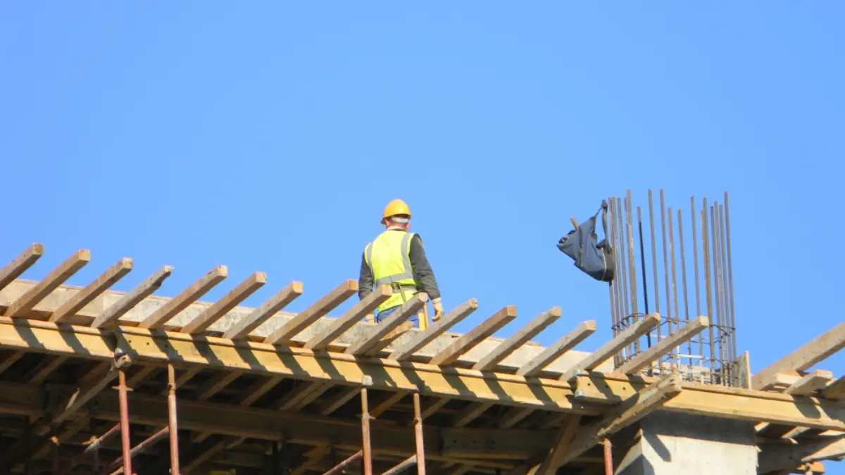 Construction worker on top of a residential building under construction, Tirana, Albania , Shutterstock