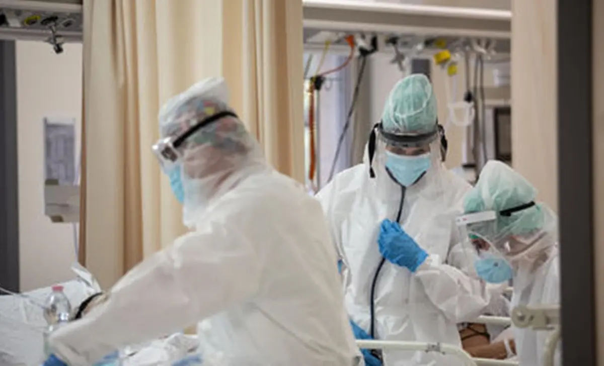Operatori sanitari, che indossano tute protettive mediche e mascherine, al lavoro nella terapia intensiva dell'Ospedale Sant'Orsola di Bologna, 12 novembre 2020. Ansa/Max Cavallari