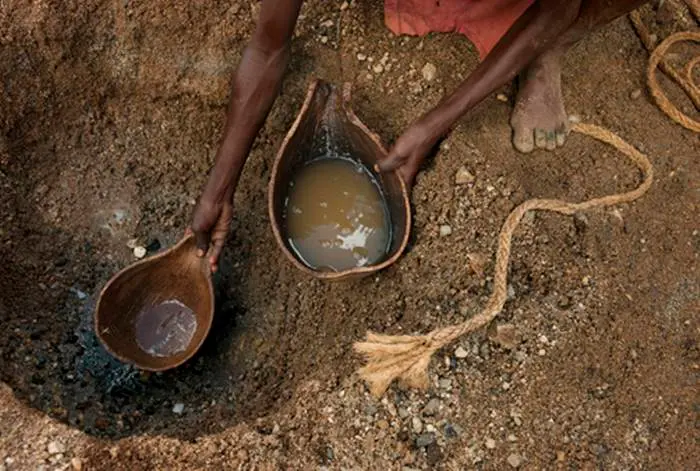 Women scratching for water from the sand of the once full Arayo River.