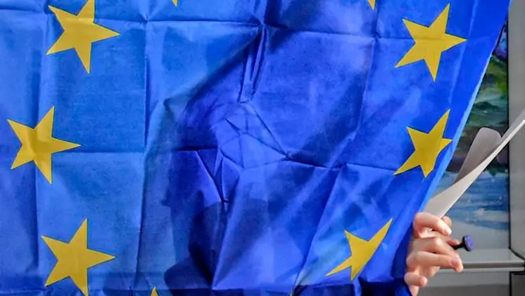 A woman exits a voting cabin with curtains depicting the European Union in Baleni, Romania, Sunday, May 26, 2019. The ruling Social Democratic Party (PSD) suffered a major blow in the European Parliament elections according to the country\\'s only exit poll. (AP Photo/Andreea Alexandru) , AP