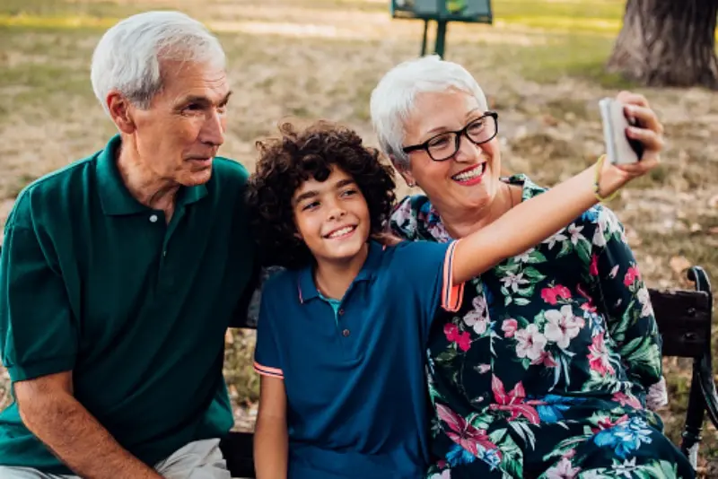 Grandson taking a selfie with his grandparents in the park