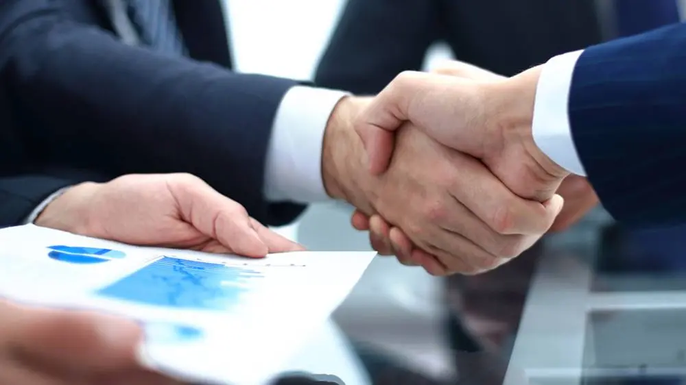 handshake business colleagues in office