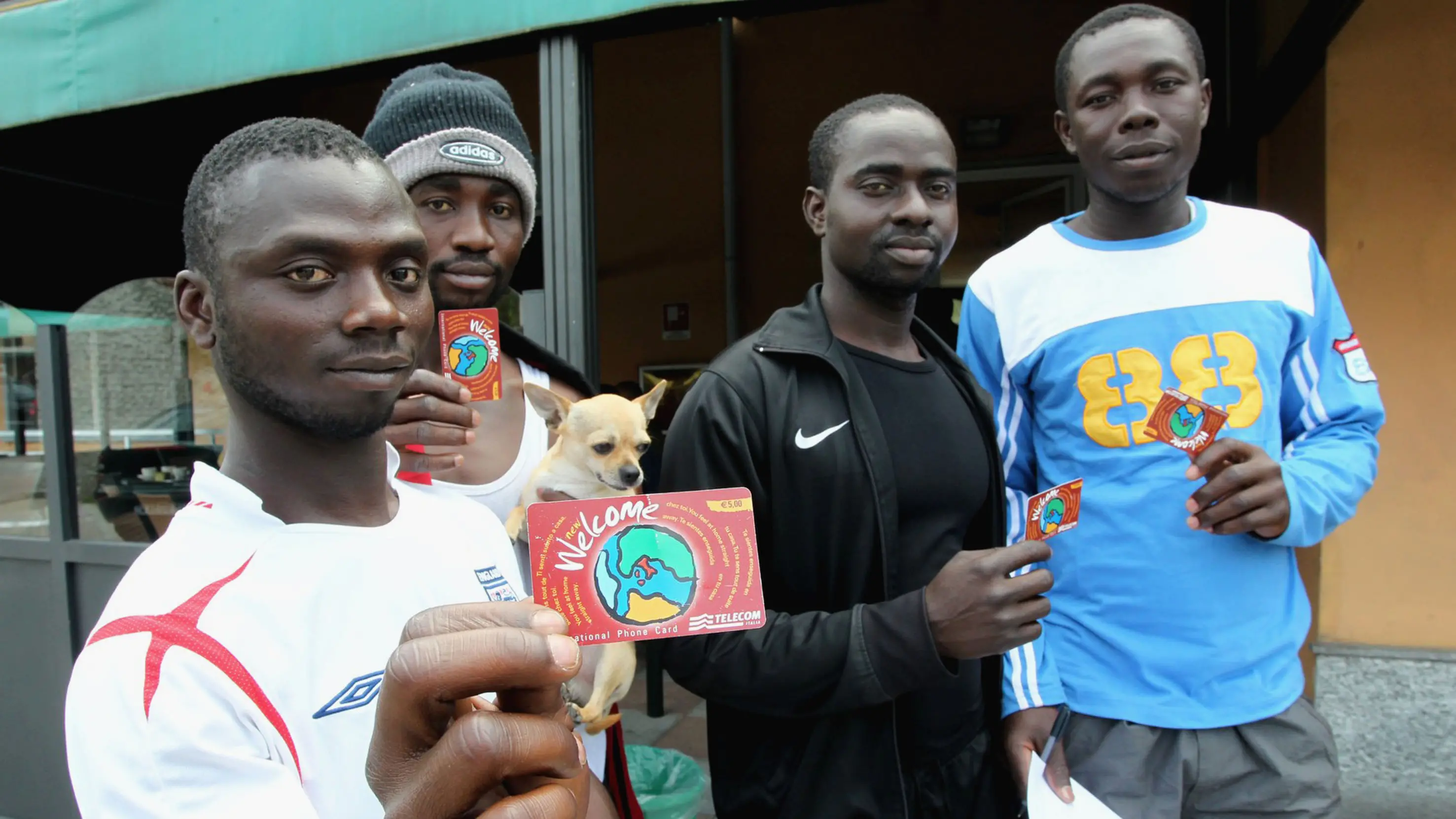 Case Nuove di Somma Lombardo (Varese), i profughi da Lampedusa accolti (in hotel) nel cuore della Lombardia. Circa 35 rifugiati di varie nazionalit\\u00E0, che risiedevano in Libia e sono scappati dalla guerra, rimarranno fino a un massimo di sessanta giorni all\\'hotel Cervo di Case Nuove in attesa di ottenere il permesso di soggiorno. Il loro arrivo, per\\u00F2, non ha mancato di sollevare qualche polemica. In foto gli immigrati davanti all\\'albergo mostrano le tessere telefoniche Telecom donate al loro arrivo, con la scritta \"Welcome\" , varesepress/IPA