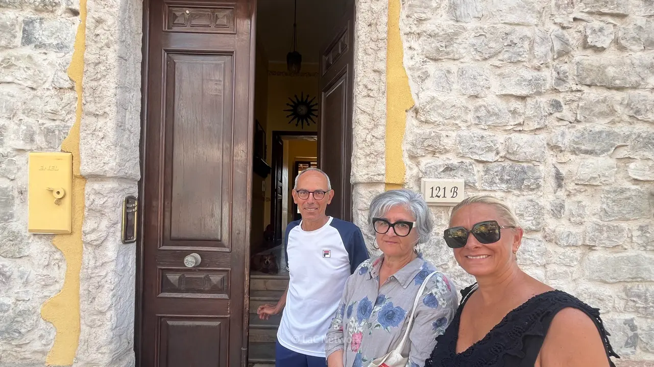 <p>Tonino Tringali con Piera Lamperti e Raffaella Corradini davanti alla casa del confino di Cesare Pavese a Brancaleone, nel reggino</p>\\n