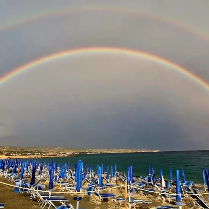 Lo spettacolo del doppio arcobaleno sulla spiaggia di Vibo Marina: magia della natura dopo la pioggia agostana