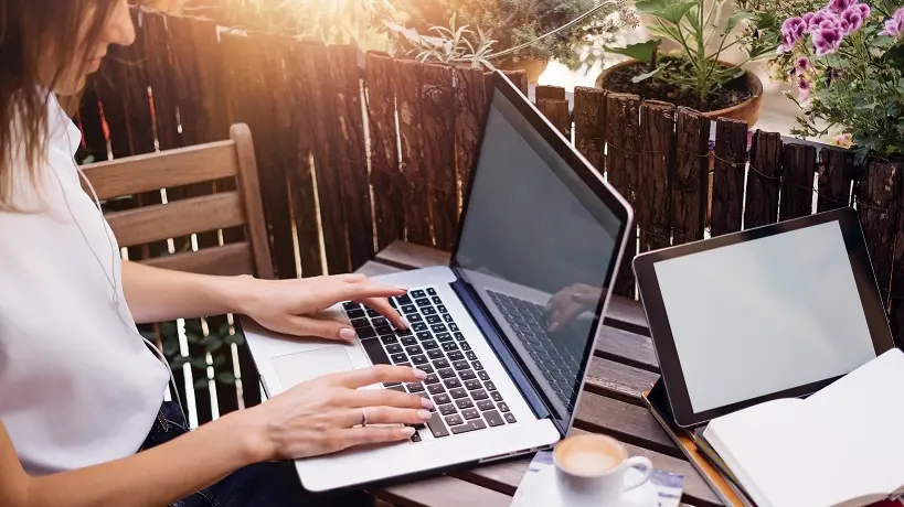 Young woman working with laptop on summer balcony , Rymden - stock.adobe.com