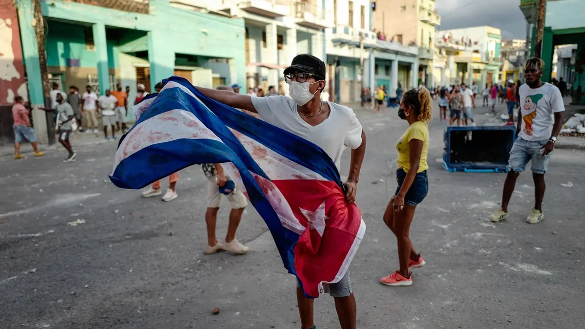 A man waves a Cuban flag during a demonstration against the government of Cuban President Miguel Diaz-Canel in Havana, on July 11, 2021. - Thousands of Cubans took part in rare protests Sunday against the communist government, marching through a town chanting \"Down with the dictatorship\" and \"We want liberty.\" (Photo by ADALBERTO ROQUE / AFP) (Photo by ADALBERTO ROQUE/AFP via Getty Images) , AFP via Getty Images