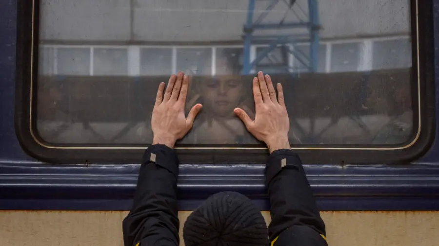 Aleksander, 41, presses his palms against the window as he says goodbye to his daughter Anna, 5, on a train to Lviv at the Kyiv station, Ukraine, Friday, March 4. 2022. Aleksander has to stay behind to fight in the war while his family leaves the country to seek refuge in a neighboring country. (AP Photo/Emilio Morenatti) , APN