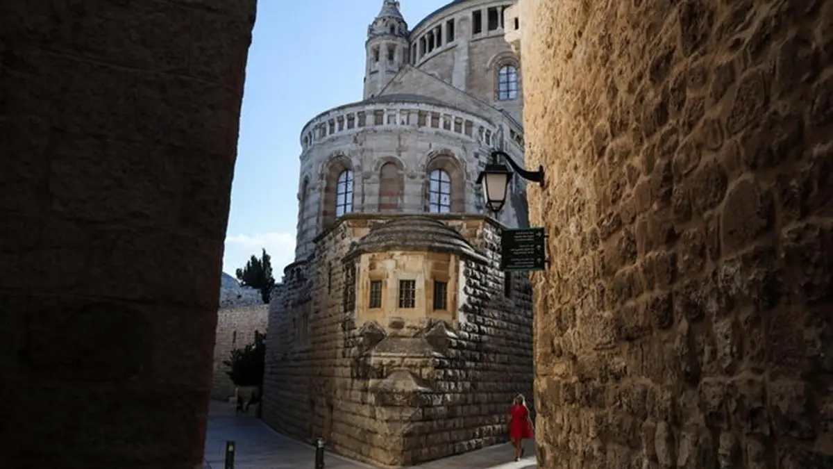 epa10119114 A women walks next to Dormition Abbey in the Old City of Jerusalem, Israel, 13 August 2022. EPA/ABIR SULTAN , EPA