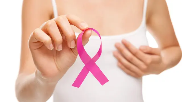 Woman with breast cancer awareness ribbon , Getty Images/iStockphoto