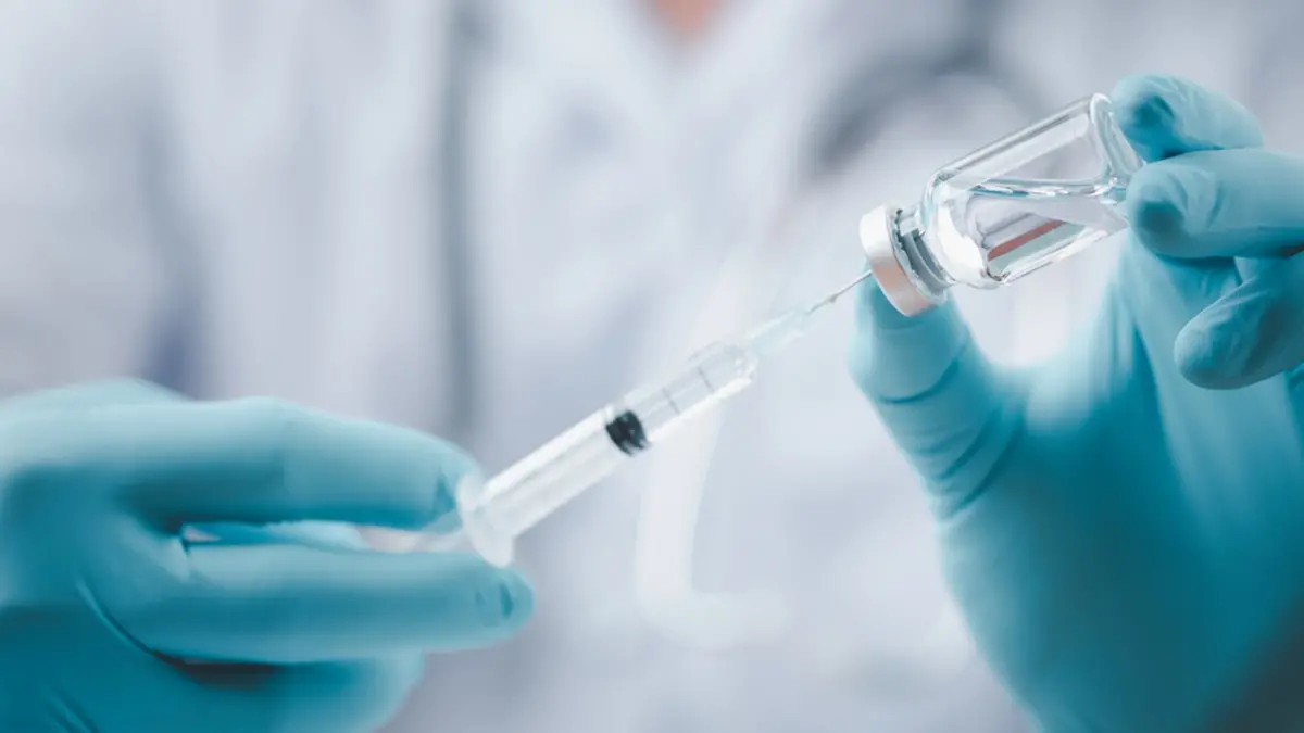 Concept fight against virus covid-19 corona virus, doctor or scientist in laboratory holding a syringe with liquid vaccines for children or older adults,Concept:diseases,medical care,science. , Shutterstock