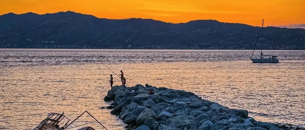 LA FOTO DEL GIORNO | Scogli, lenze e tramonti: storie di Pezzo sullo Stretto