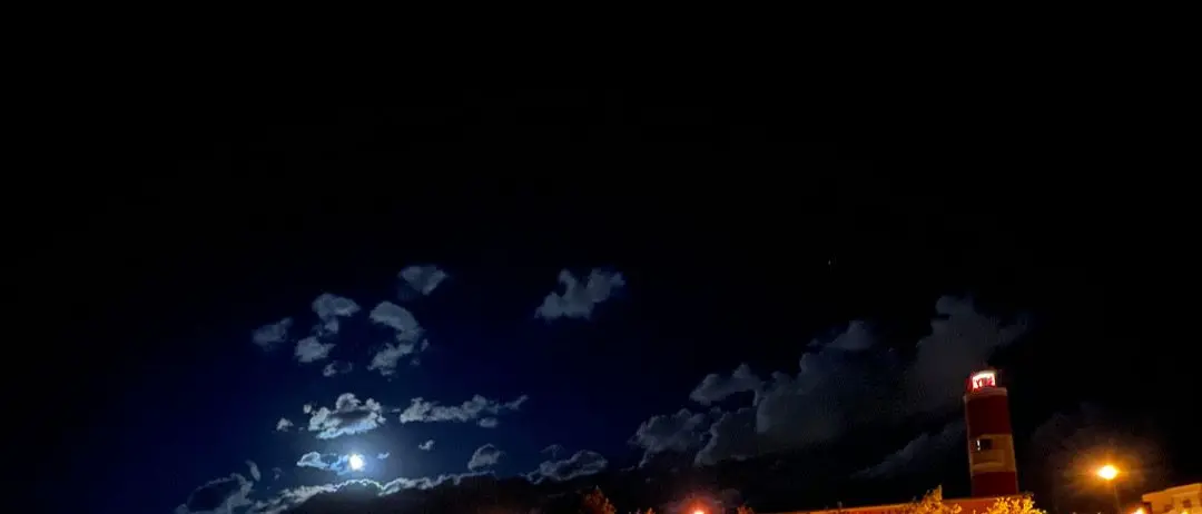 LA FOTO DEL GIORNO | Il faro, la luna e il mare: poesia notturna sul lungomare di Pezzo