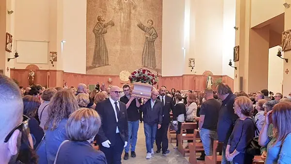 Folla attonita per l'addio a Piero. Trovato il cellulare