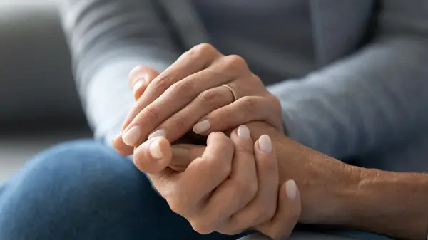 Close up caring grown up daughter holds mother hand provides psychological support, touch arms symbol of asking of forgiveness, heart-to-heart talk with reliable person, empathy and compassion concept , Getty Images/iStockphoto