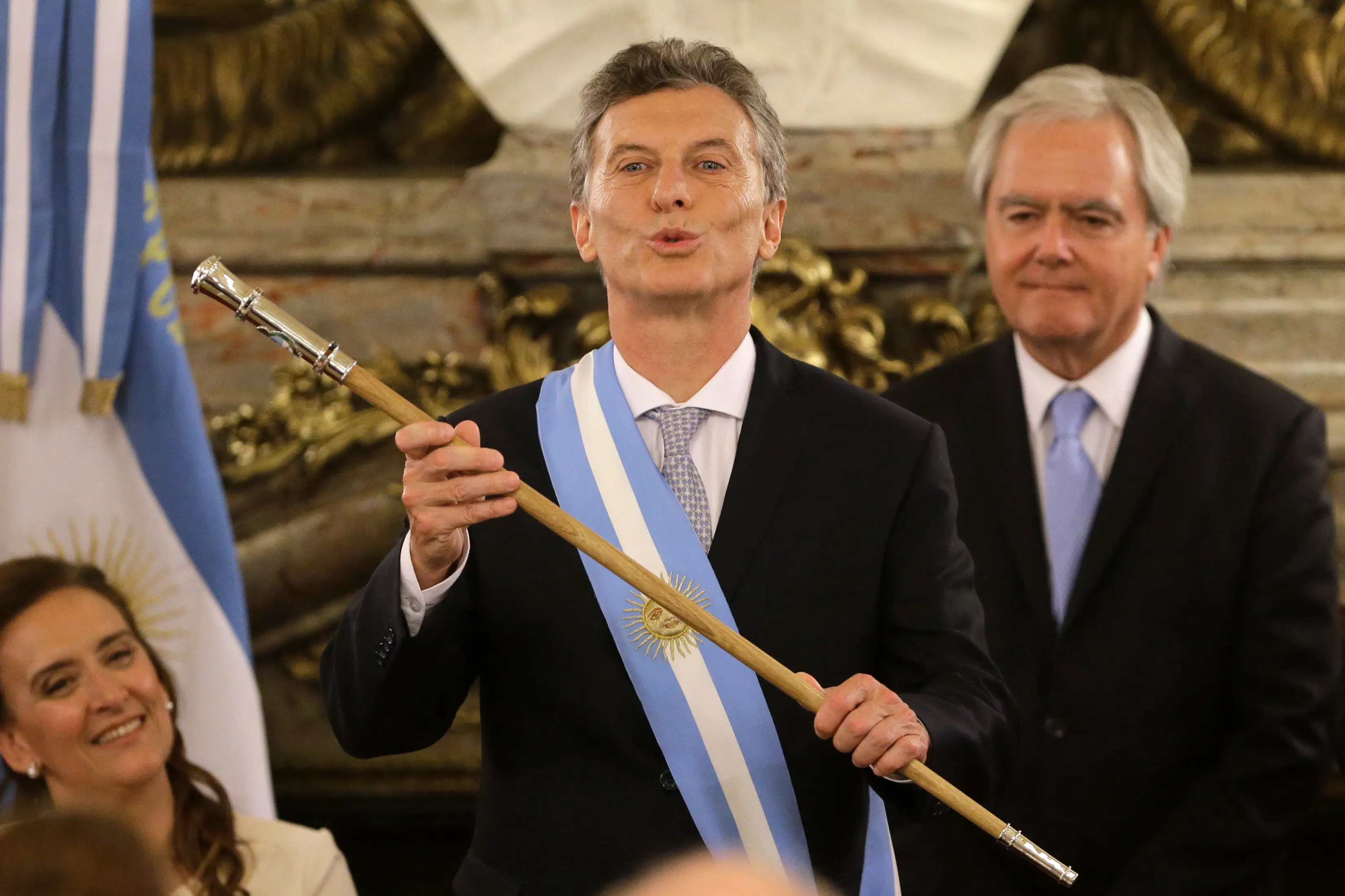 Argentina's new President Mauricio Macri gestures after receiving the presidential sash from acting Senate President Federico Pinedo, right, at the government house or \\\"Casa Rosada\\\" in Buenos Aires, Argentina, Thursday, Dec. 10, 2015. The 56-year-old ran on promises to usher in an era of more civil discourse and roll back much of the Fernandez administration spending that many economists say has brought Argentina to the brink of another financial crisis. (AP Photo/Victor R. Caivano)