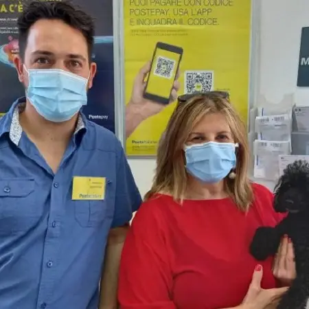 Andali, una donna assicura il suo cane alle Poste