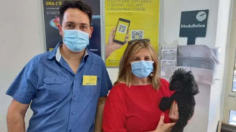 Andali, una donna assicura il suo cane alle Poste