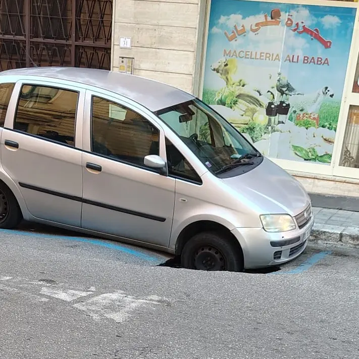 Reggio, auto incastrata in una voragine in pieno centro\n